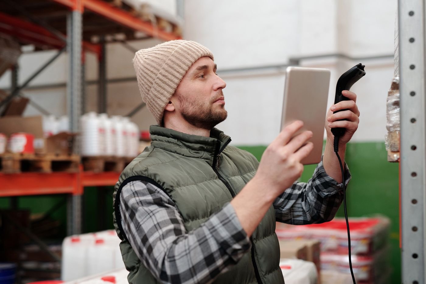Stock worker scanning inventory beside storage shelves