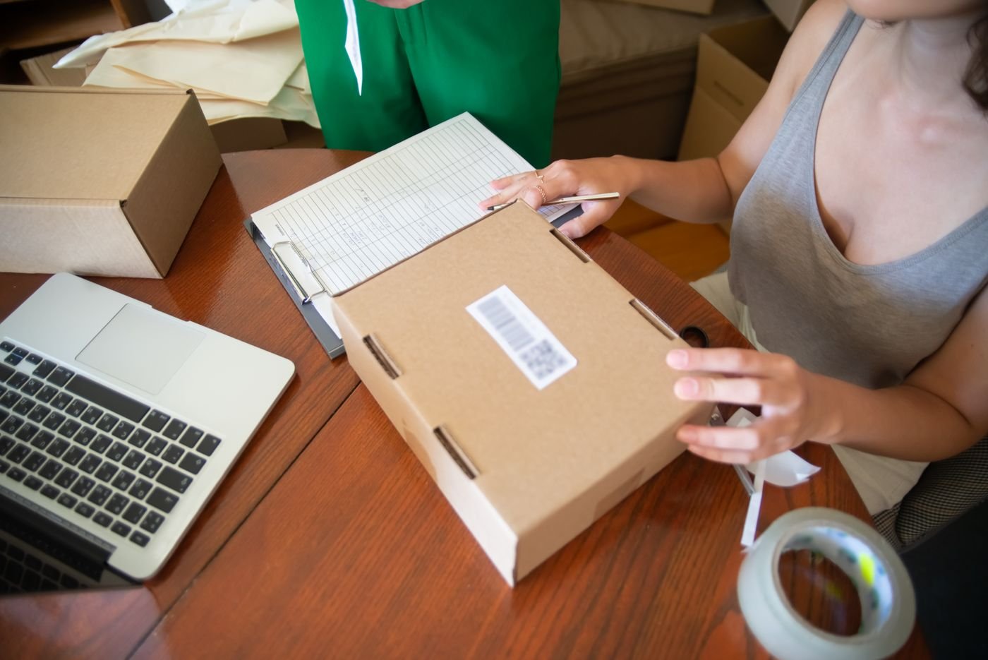 Preparing an online order beside a laptop and packing supplies