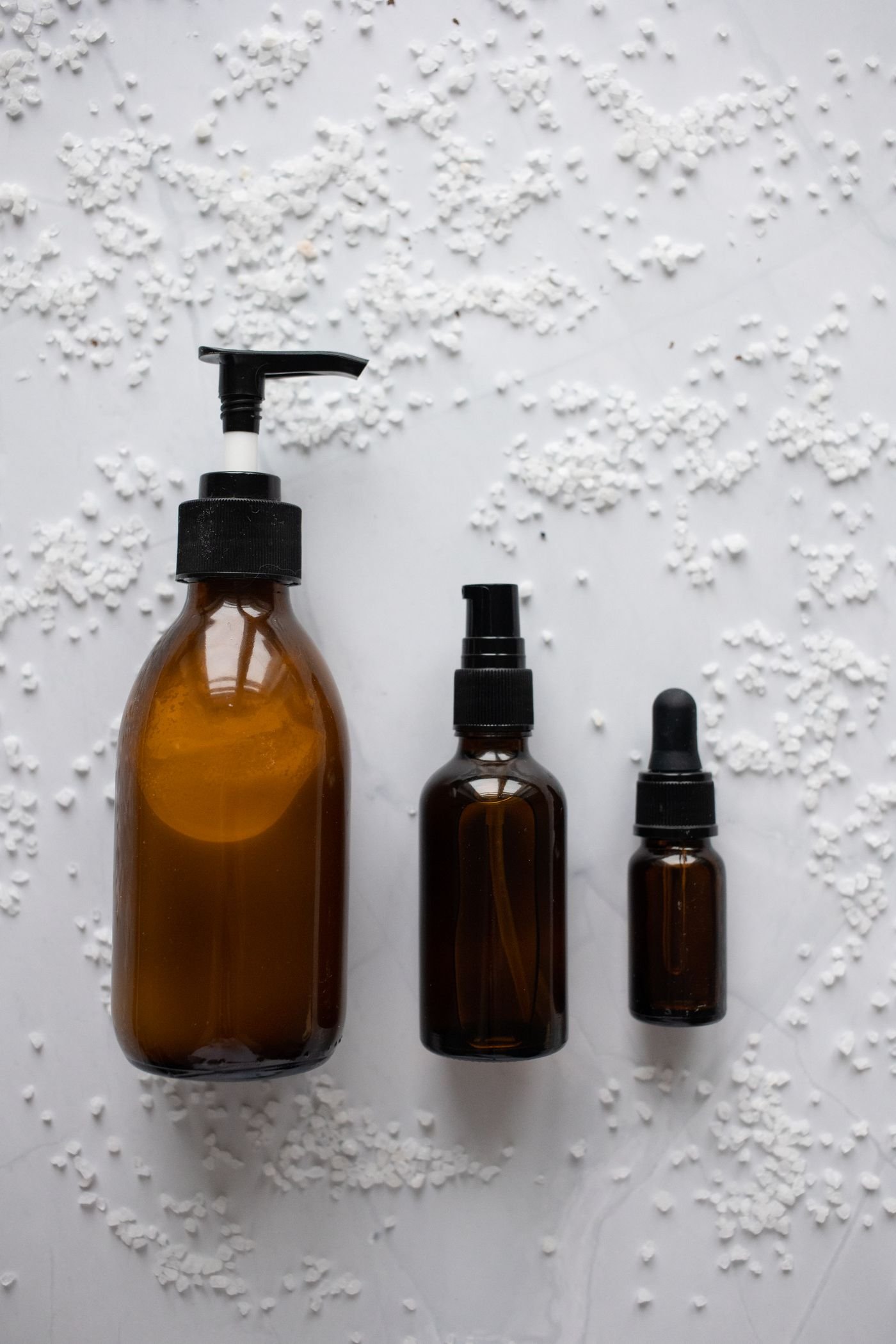 Unlabelled consumer product bottles on a neutral background